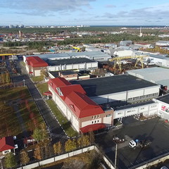 А это город Когалым, а если говорить точнее, то  Восточная промзона, на которой и расположилась производственная площадка и головной офис Общества «ЛУКОЙЛ ЭПУ Сервис». С высоты птичьего полёта перед нашим взором открываются здания цехов, участков и складов. На территории чистота и порядок. Если более внимательно присмотреться к фотографии, то вдали можно увидеть небольшую часть города и движущийся поезд, олицетворяющий собой вечное движение людей, приехавших покорять северные просторы нашей необъятной Родины. 
